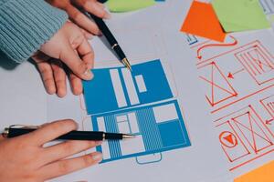 A person is holding a pen and paper with a piece of paper with a design on it photo