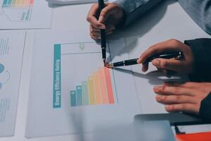 Two people are working on a chart on a white table photo
