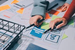 Two people working on a project with a basket of papers photo