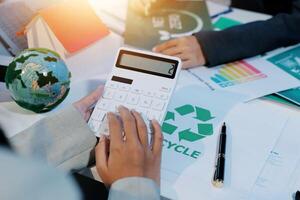 Recycling concept with calculator and business people working on paper photo