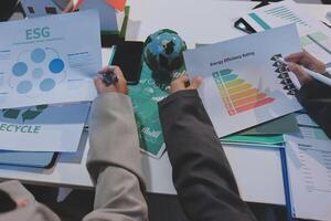 Business people working on paper with eco-friendly information photo