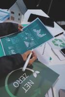 A man is working on a paper with a green recycling symbol photo