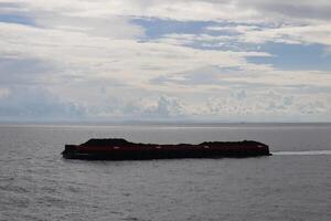 A large boat floating in the ocean with a few people on it photo