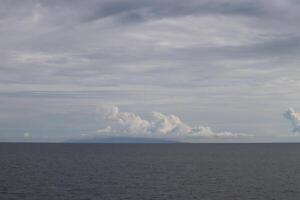 A large body of water with a plane flying over it photo