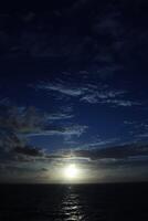 The sun sets over the ocean in this photo