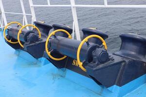 A row of three yellow and blue pipes on a boat photo