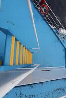 A blue boat with a yellow railing photo