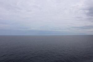 A large body of water with a few clouds photo