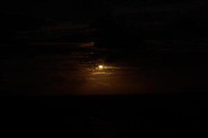 The moon is setting behind the clouds in this photo