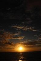 The sun setting over the ocean photo