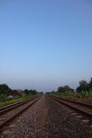 A train going down a track with a sky in the background photo