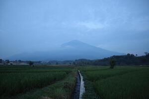A view of a mountain in the distance with a road photo
