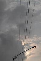 A street light with a cloudy sky behind it photo