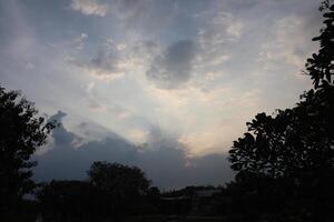 A cloudy sky with sun rays shining through photo