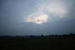 A view of a cloudy sky with a plane flying in it photo