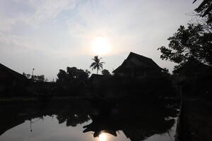 The sun is setting behind the buildings photo