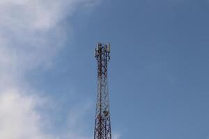 A cell phone tower with a blue sky in the background photo