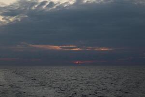 A boat on the ocean with a sunset in the background photo