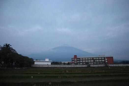 un grande montaña en el distancia con un edificio en el primer plano foto