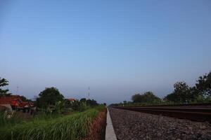 A train is traveling down a track with a blue sky photo