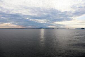 A large body of water with a mountain in the distance photo