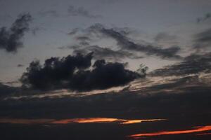A dark cloud is seen in the sky at sunset photo