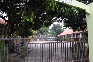 A green gate with a sign on it photo