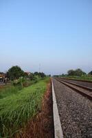 A train going down a track with grass and trees photo