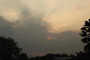 A plane flying over a cloudy sky with sun rays photo