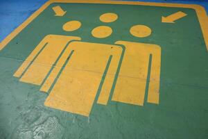 A green and yellow sign with people on it photo