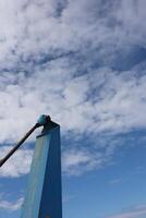 A blue pole with a white rope attached to it photo