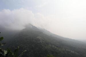 A view of a mountain range with a plane flying over it photo