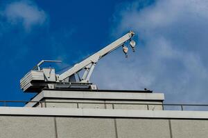 A construction crane is positioned on the rooftop of a building, set photo