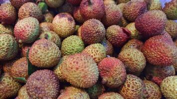 A stack of ripe red fresh lychee fruits photo
