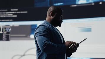 africano americano codificador especialista imersão dentro Programas desenvolvimento para uma Alto tecnologia trabalhos ambiente, focado em computador portátil tela. engenheiro desfrutando codificação vida e isto nuvem Informática. Câmera b. video