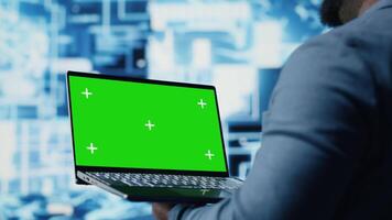 Black male engineer showing laptop with chroma key display next to predictive analytics immersed in AI brain development and deep learning. High tech cybernetics algorithms. Camera B. video