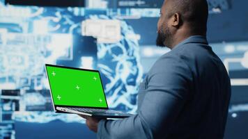 Young entrepreneur technician using advanced technology and green screen on laptop, exploring data science, automation and AI brain in a digital data visualization. Machine learning. Camera B. video