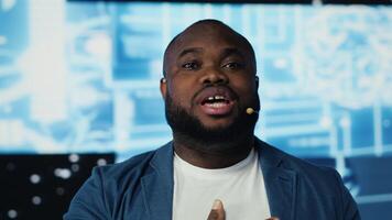 Black tech savvy presenter host does a presentation for AI brain systems, discussing about machine learning automation algorithms and data visualization at a modern conference. Camera B. video