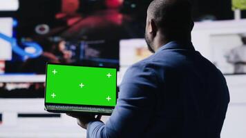 Professional content creator in a multitasking space holds green screen, leveraging social media, internet big data and cloud systems. Engaging followers to boost digital presence. Camera B. video