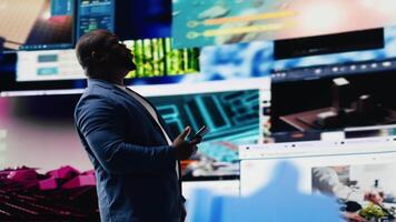 Young black person showcasing visual representation of online connection, immersed in web platforms and apps. Mobile technology surrounded by social network icons in a digital space. Camera B. video