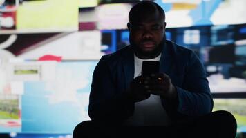 Modern guy holding his phone expressing harmful effects of social media overuse, representing social anxiety and mental health issues. Showcases isolation from the real world. Camera B. video