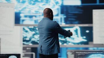 Young professional engineer focused on coding with tablet at an innovation hub, using programming language on terminal window for automation. High tech career in data science. Camera A. video