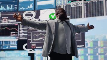 Black entrepreneur thinking about a new projection to increase revenue, evaluating infographics and financial reports with digital tech tools and analytics. Success and development. Camera B. video
