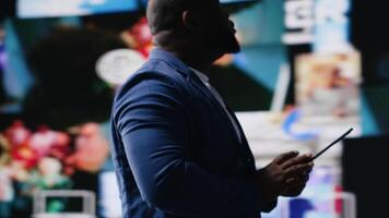 African american digital creator interacting with high tech visuals and screens, illustrating cloud based systems, e commerce trends and big data in web networking tech environment. Camera B. video