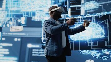 Young african american engineer focused on VR headset programming and analytics, surrounded by neural networks systems and AI data visualization. Innovation and cybernetics. Camera B. video