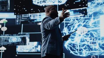 African american engineer examining artificial intelligence brain systems using cloud computing tools and advanced programming. Using machine learning for virtual assistant automation. Camera B. video
