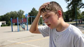 Boy outdoor sweating heat exhaustion playground summer tired Young boy sweating and looking exhausted. Heat stroke concepts photo