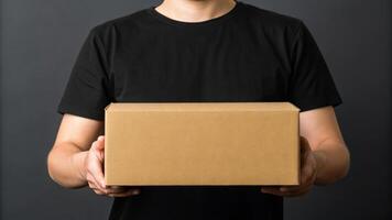 Delivery courier logistics ecommerce shipping. Man holding cardboard box delivery courier logistics shipping service black photo