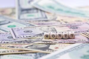 close-up of wooden cube with text MONEY on banknote dollar for business and financial concept. photo