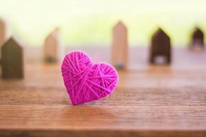 Red knitting wool in shape of heart on vintage wooden with bokeh soft light background, vintage picture style photo